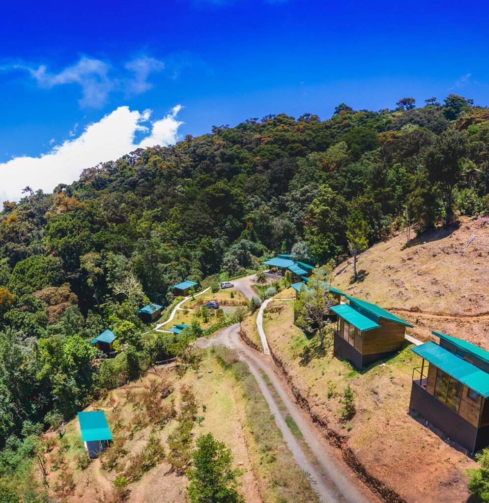 Aerial view of cabins and mountain surroundings at Gema del Bosque Lodge.